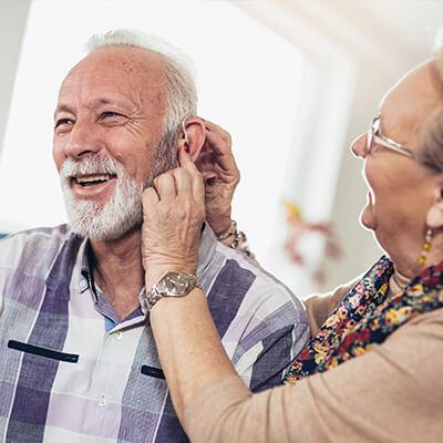 loved one having trouble with hearing assisted by wife