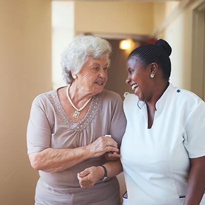a caregiver talking to a senior woman suffering from presbycusis
